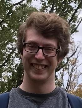 A photo of Andrew Freedman, smiling with trees in the background.